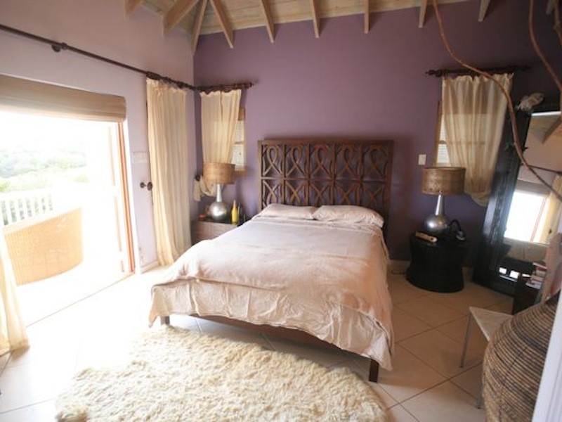 Master bedroom with doors leading to the verandah in the Calypso Dreams villa for sale St. Kitts! 